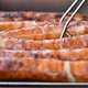 Row of bratwurst on gril